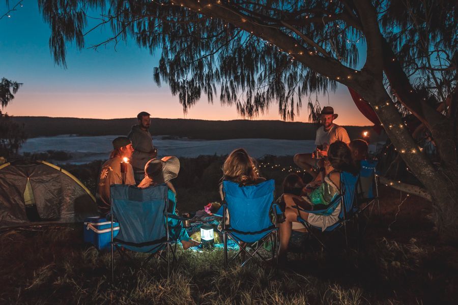 people gathered around campsite in the evening
