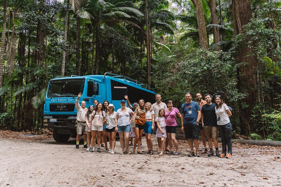 group tour in front of blue tour bus on kgari