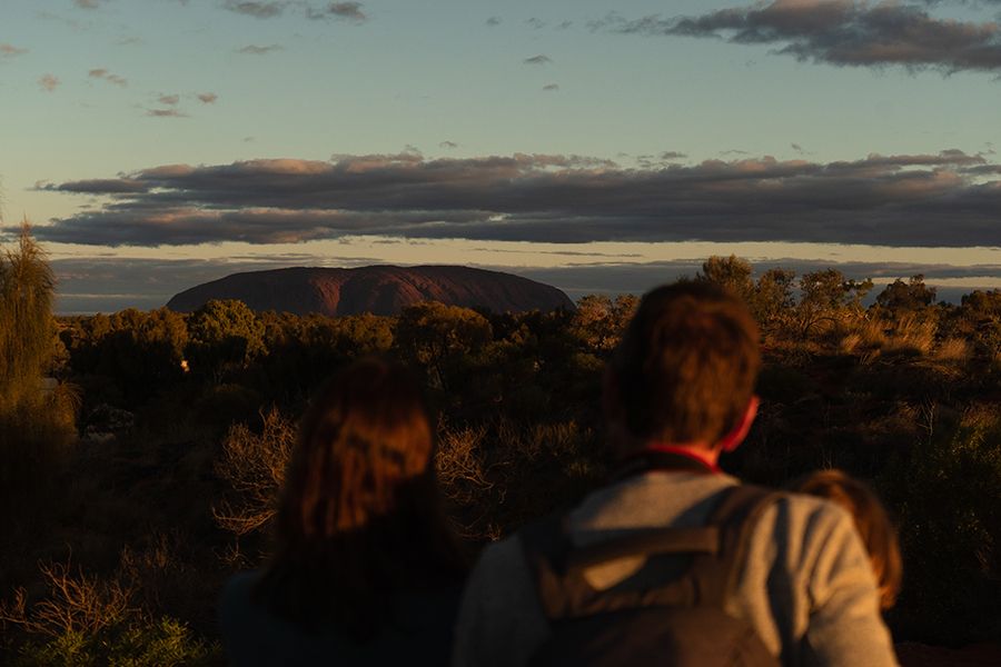 man admiring uluru before sunrise
