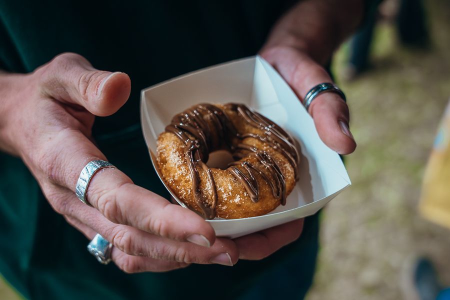 person holding a doughnut at an outdoor event