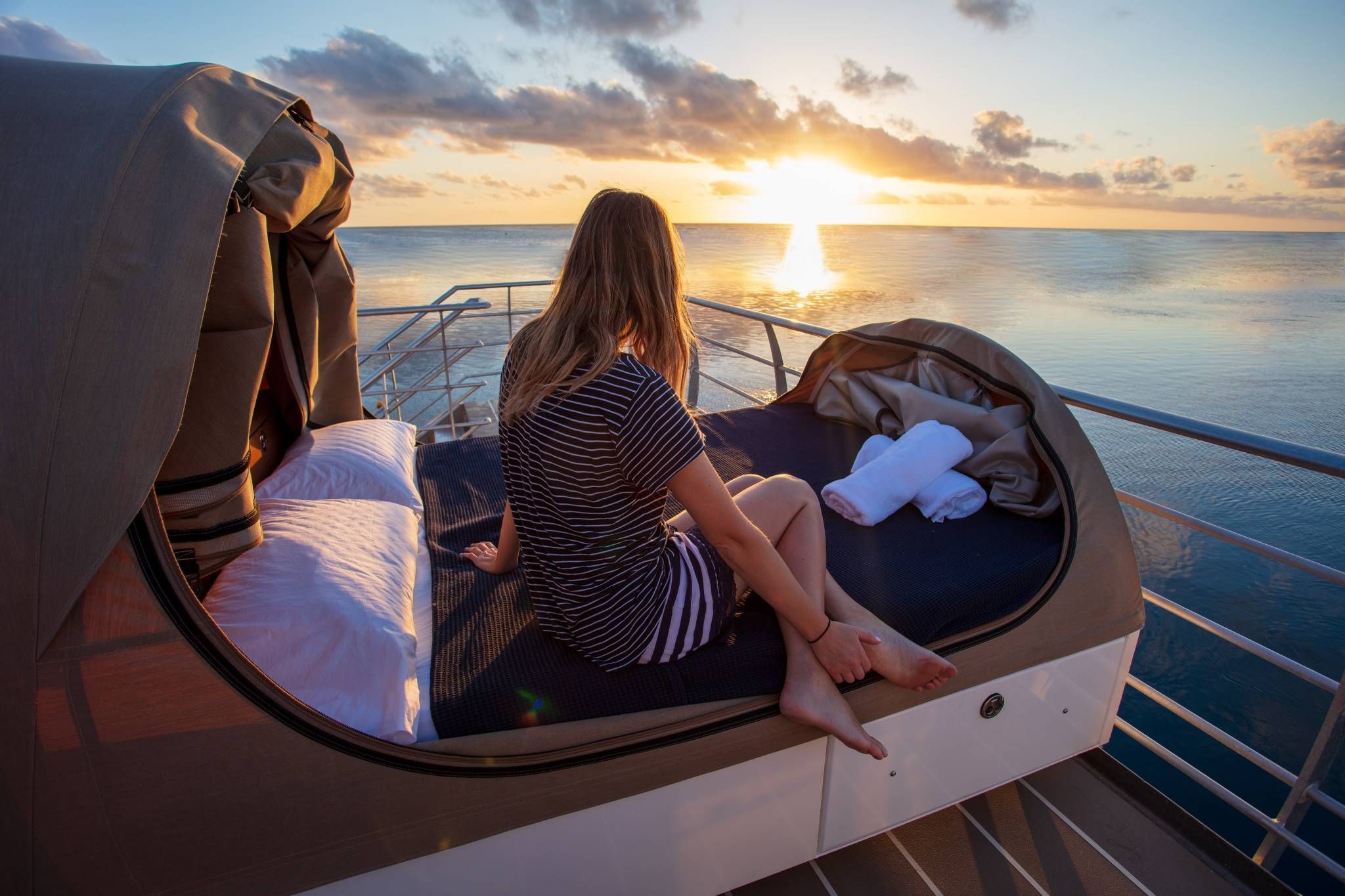 girl watching sunrise over great barrier reef on reefsleep