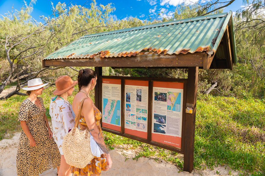 people looking at an informational sign on a kgari walk