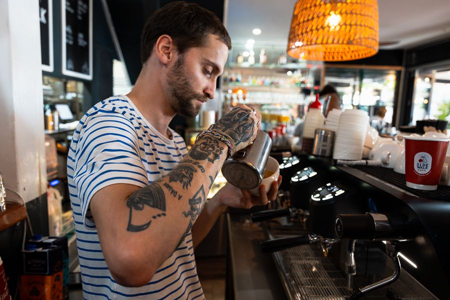barista making coffees in a cafe in australia