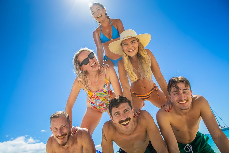 travellers making a pyramid on the beach australia