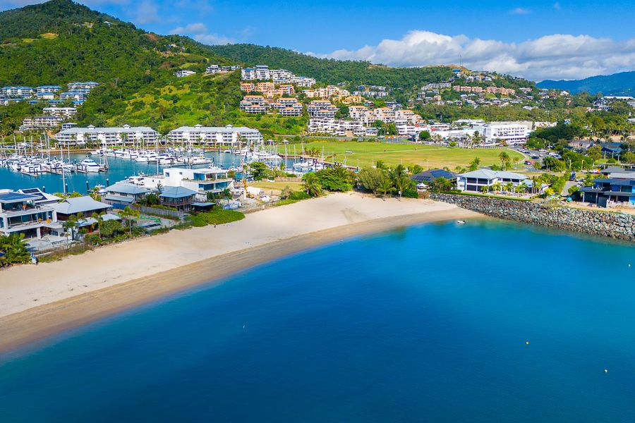 boathaven beach and nearby hills and buildings in airlie beach 