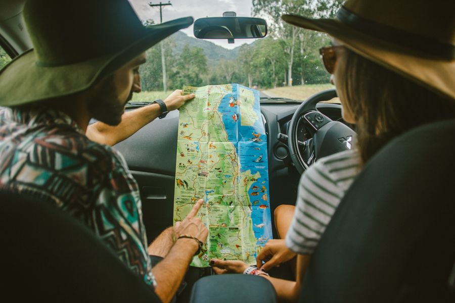 couple looking at a map while driving a car in australia