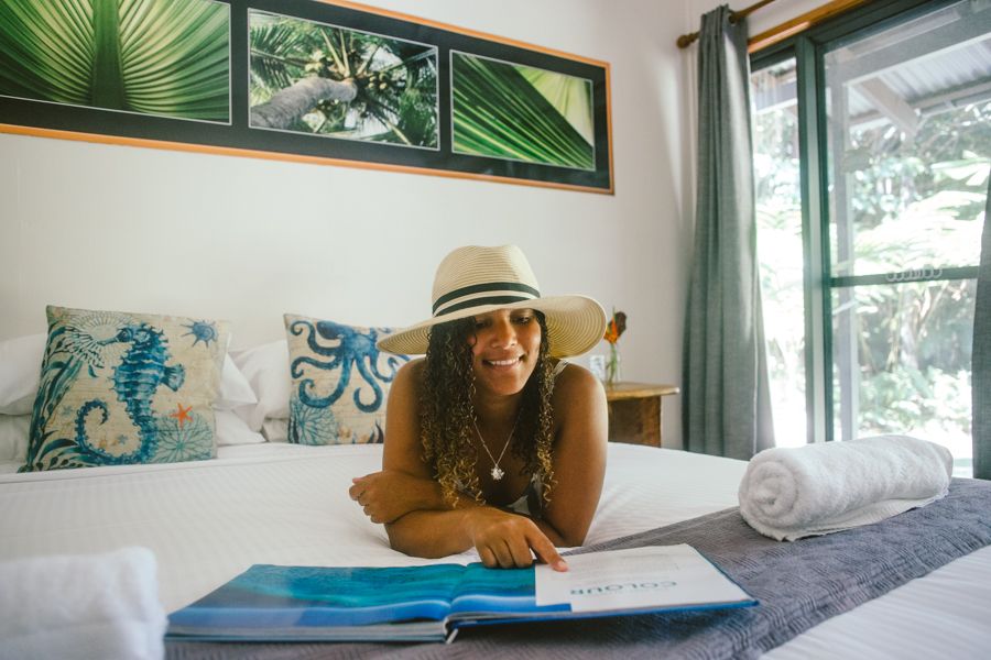 girl reading a book on a hotel bed in australia