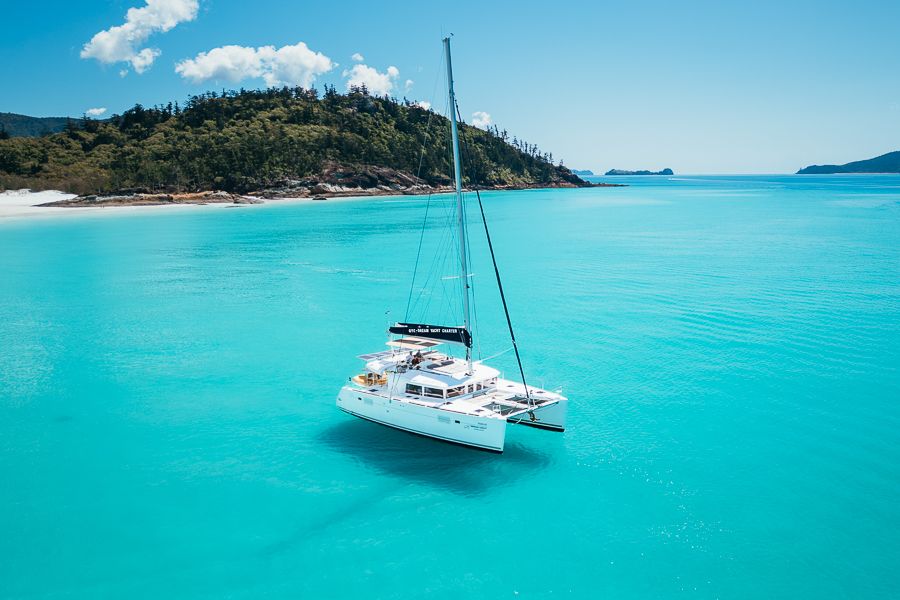 catamaran sailing over bright blue water in the whitsundays