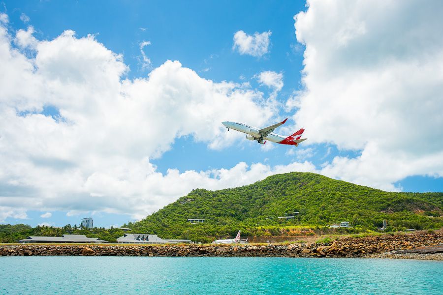 plane flying over hamilton island airport in the whitsundays