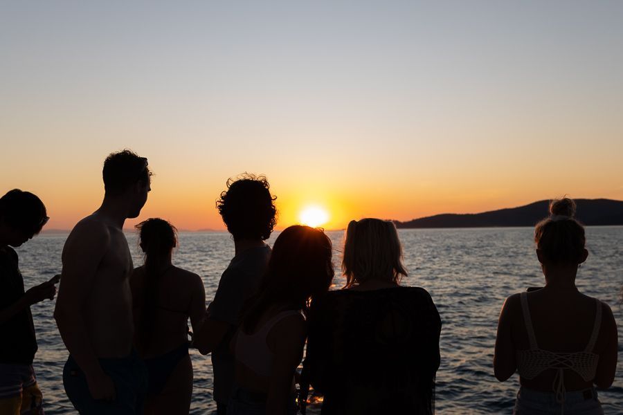 group of travellers watching the sunset on a cruise