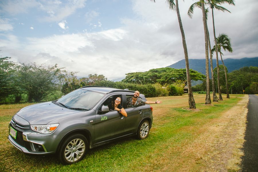 Rental Car Cairns couple smiling in a rental car on a rural queensland road