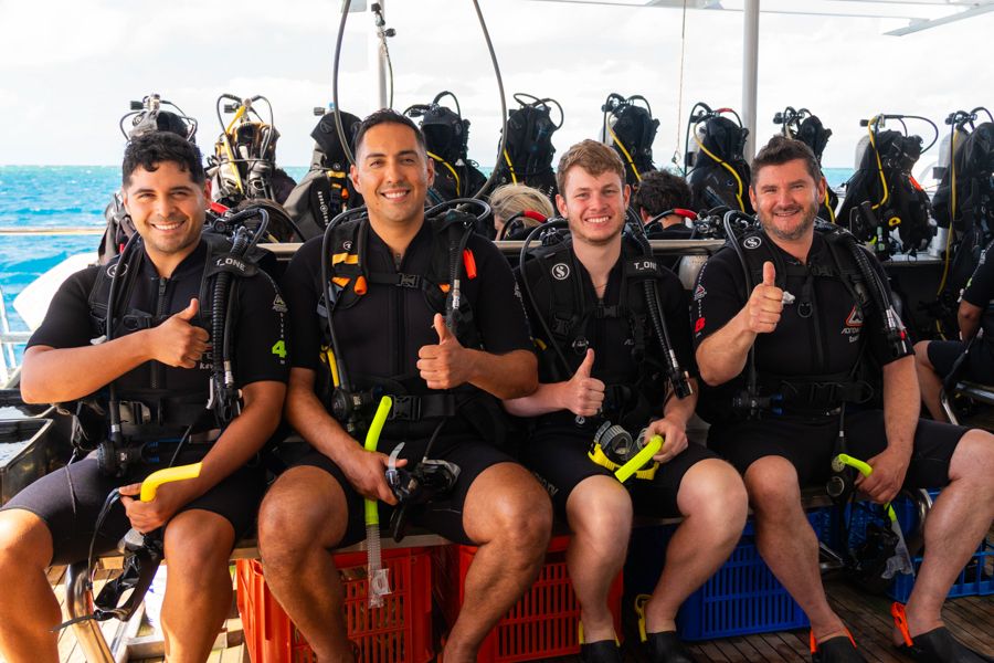 Cairns Scuba Diving Tour four guys in scuba gear smiling on a great barrier reef tour