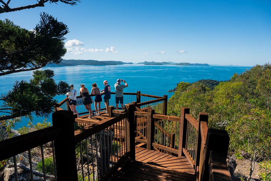 A group of people standing at a lookout over the ocean