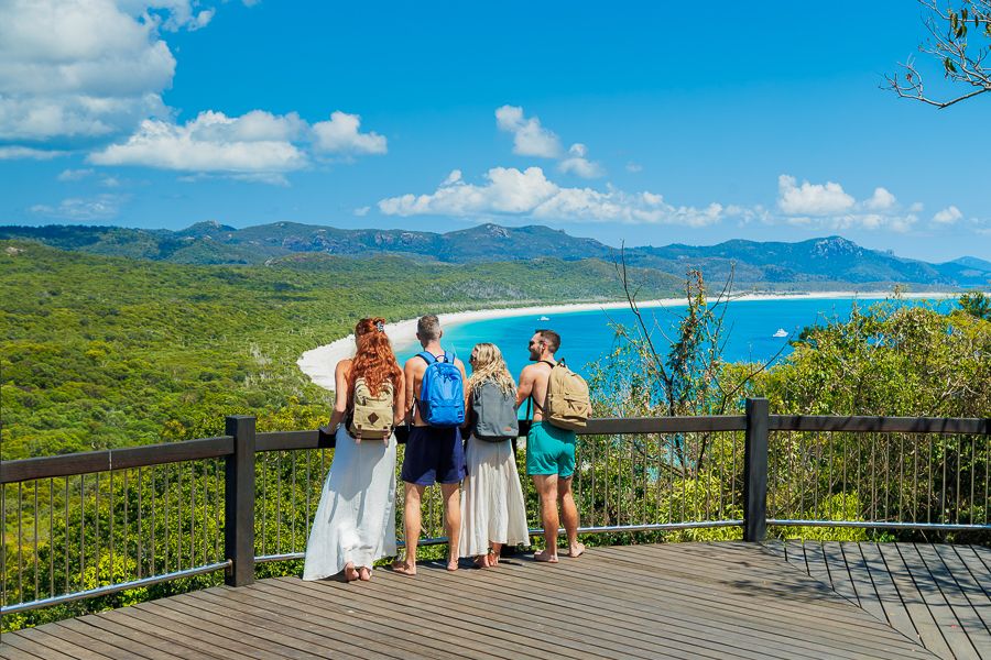 A group of people standing at a lookout over the ocean