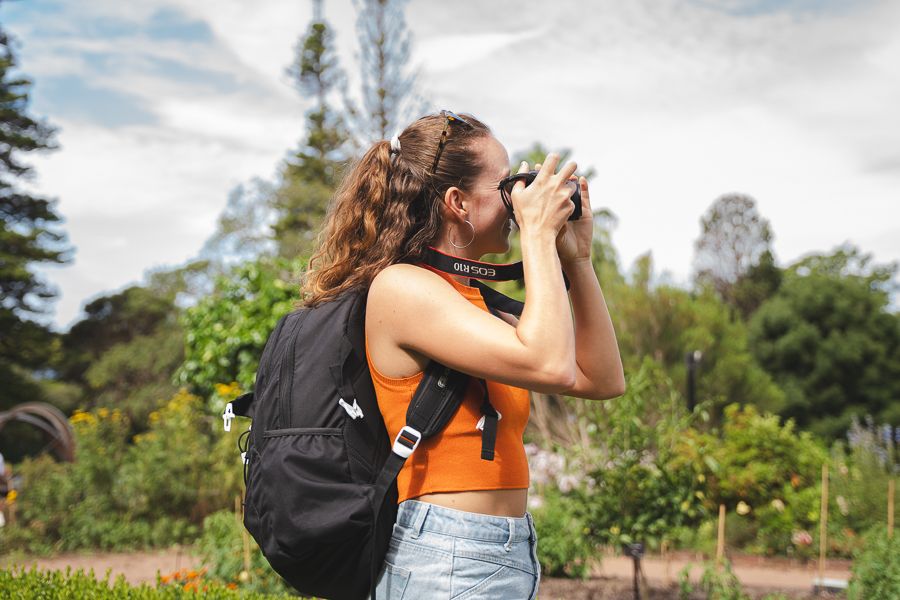 girl taking photos in a botanic garden in australia