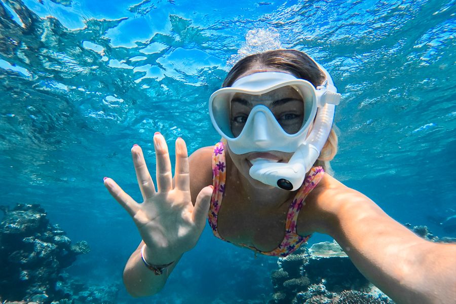 a woman wearing a white snorkelling mask underwater