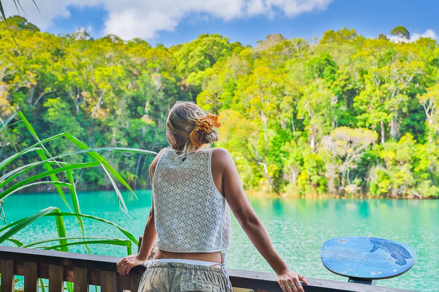 a woman standing on a boat looking out at a lake