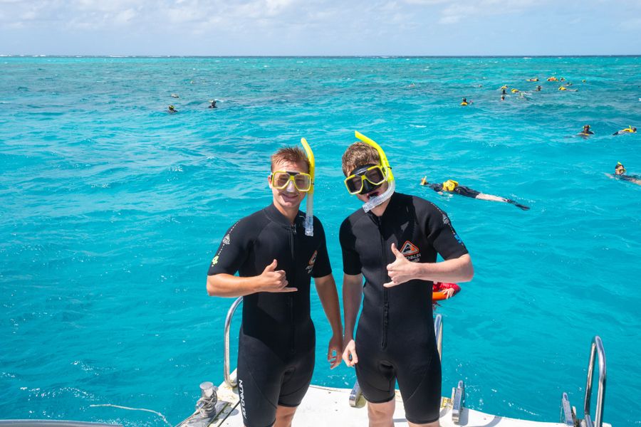 two men wearing snorkel masks on the great barrier reef