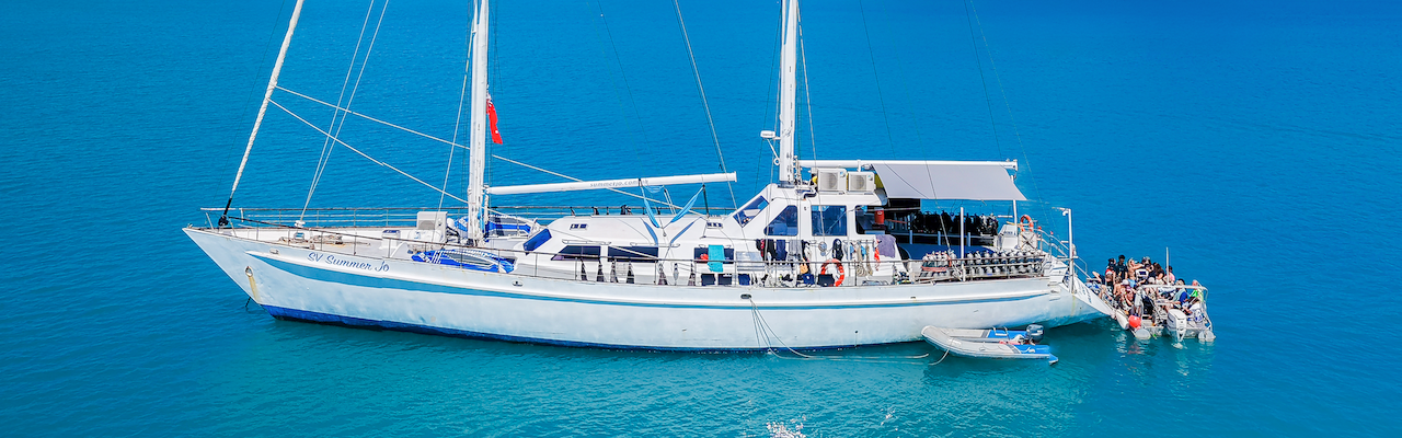 a drone shot of a sailing boat at anchor