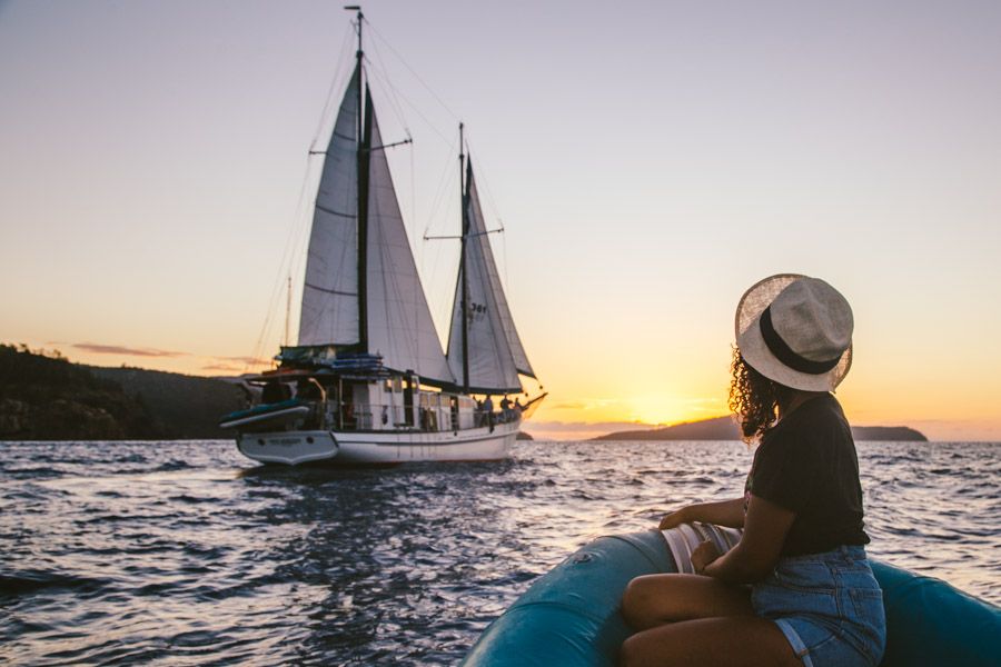 Girl looking a vessel at sunset, Whitsundays, Australia