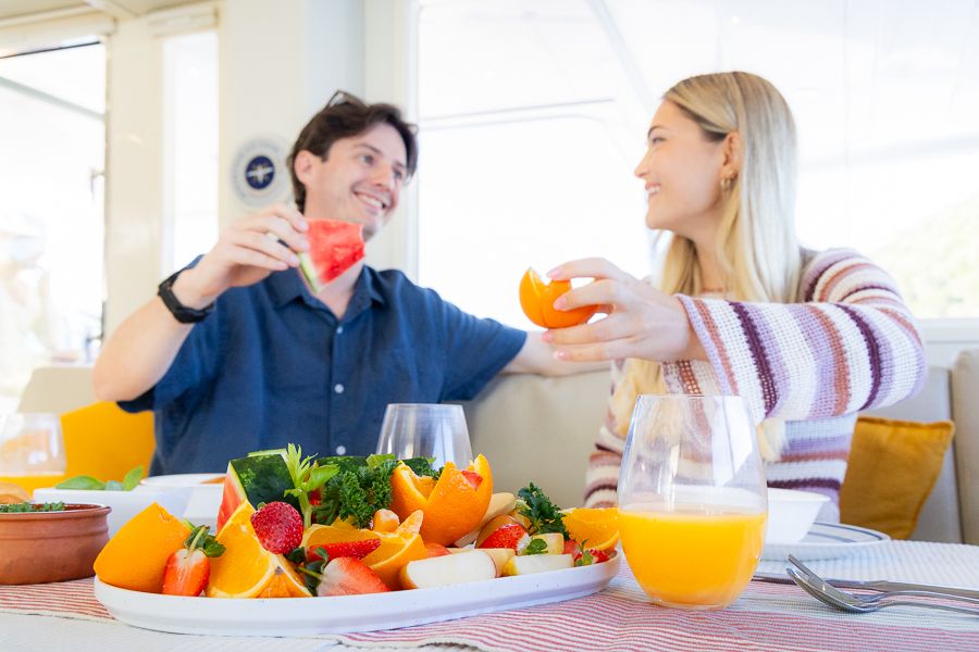 couple sharing a fruit platter on whitehaven dreamer sailing tour