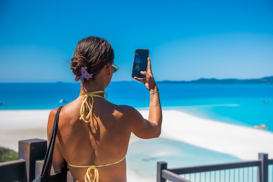 girl taking a photo of the whitsunday islands