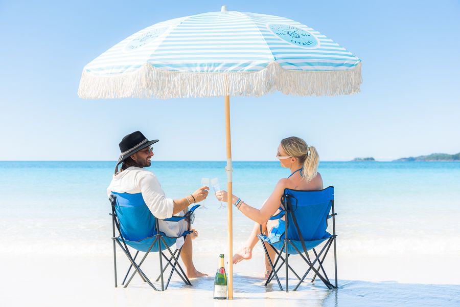 Whitsundays Weather a man and woman sitting together under a beach umbrella