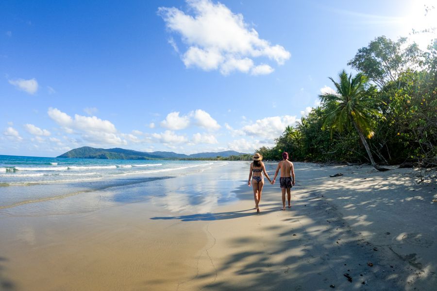 couple walking on myall beach daintree rainforest