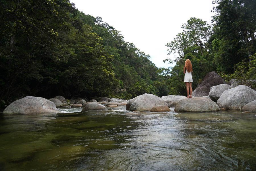 girl standing on rocks in mossman gorge daintree rainforest
