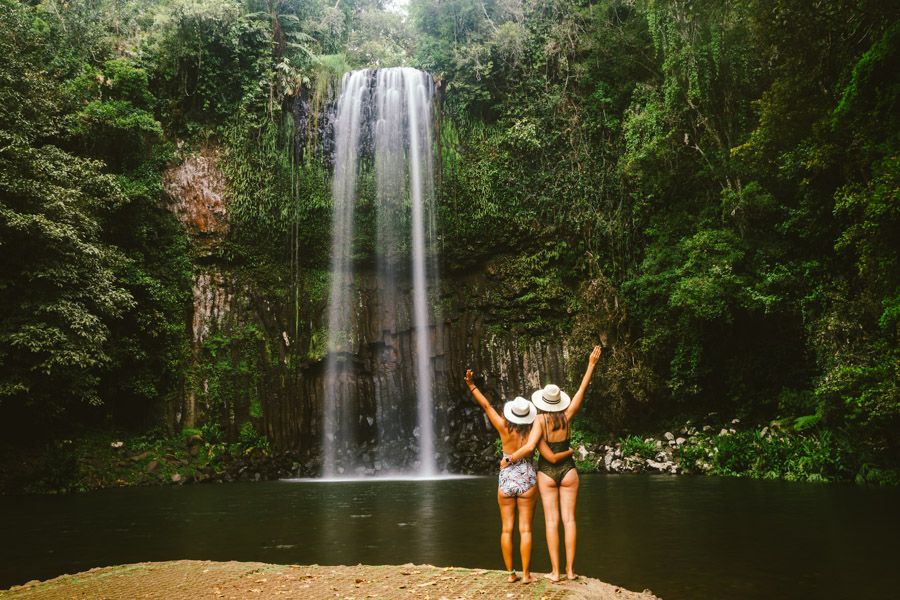 Two women standing in front of the Millaa Millaa Waterfall, Cairns 