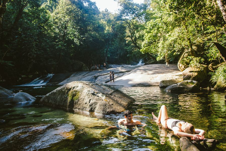 Three people relaxing at Josephine Falls, Atherton Tablelands