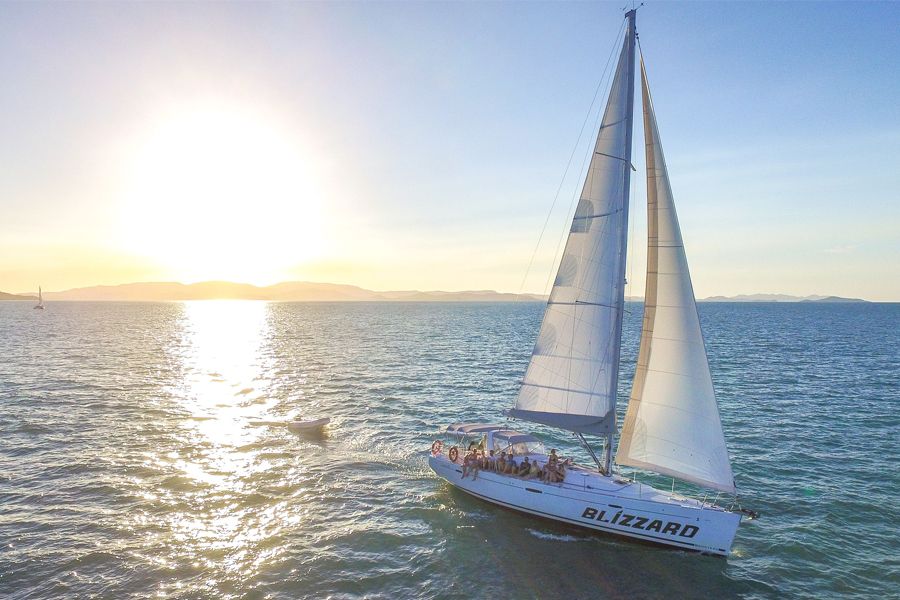 Blizzard sailing yacht in the Whitsundays, sails up at sunset